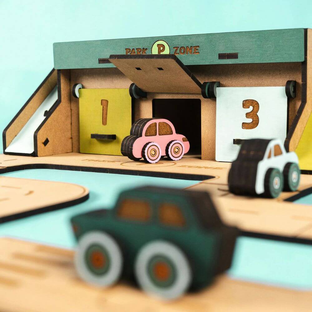 Wooden toy garage with toy cars on a light blue background