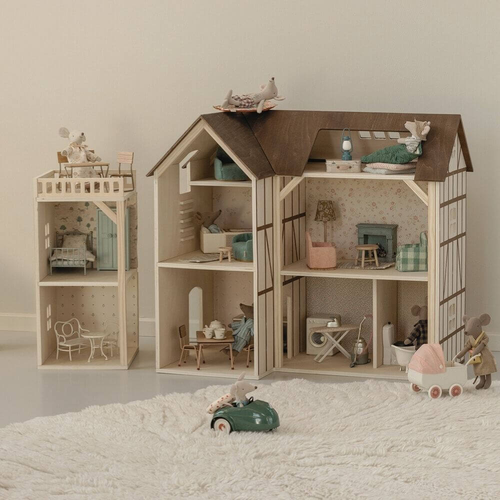 Maileg Wooden farmhouse with furniture and toys on a white carpet