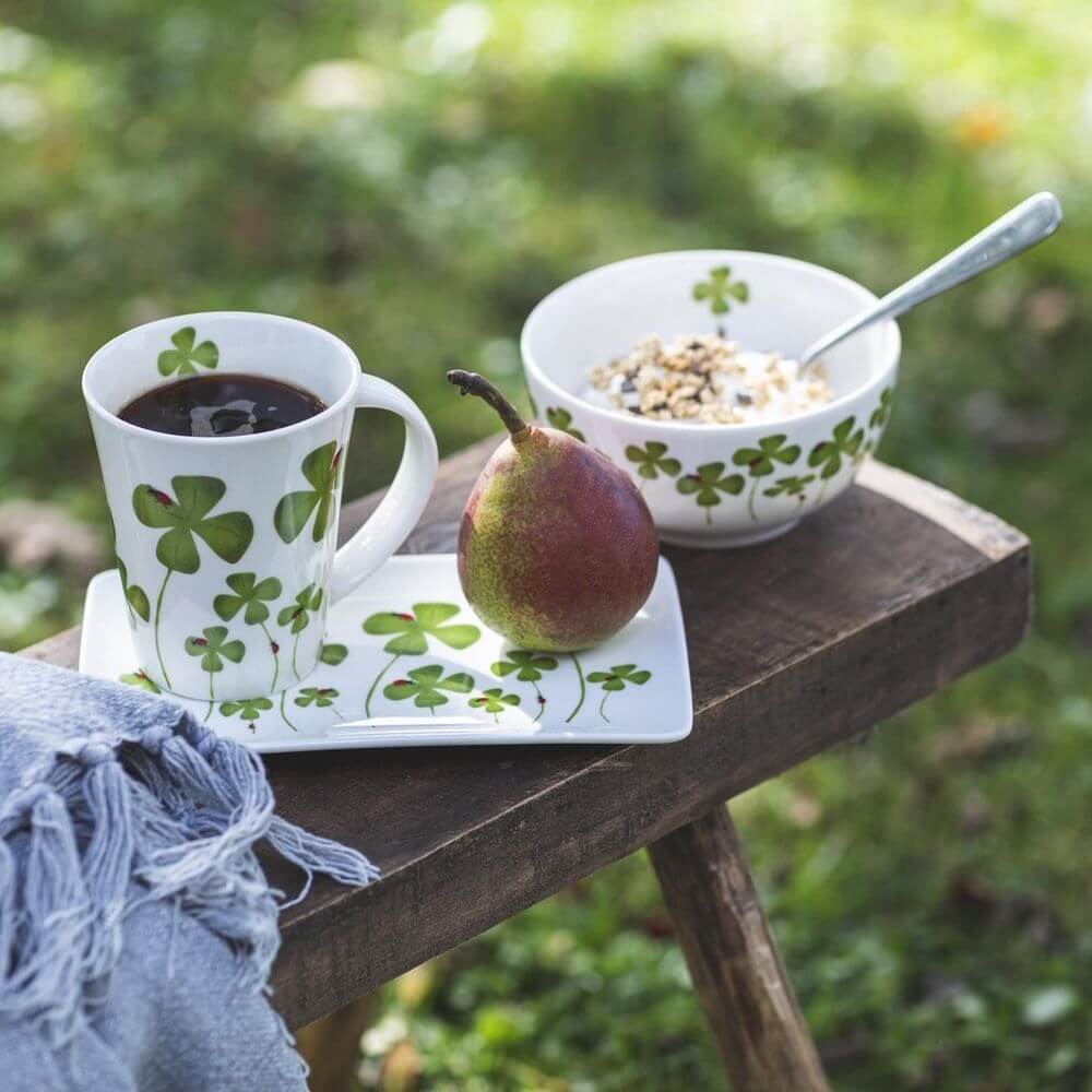 Naasgransgarden Clover plate, bowl and cup sitting on a bench outside